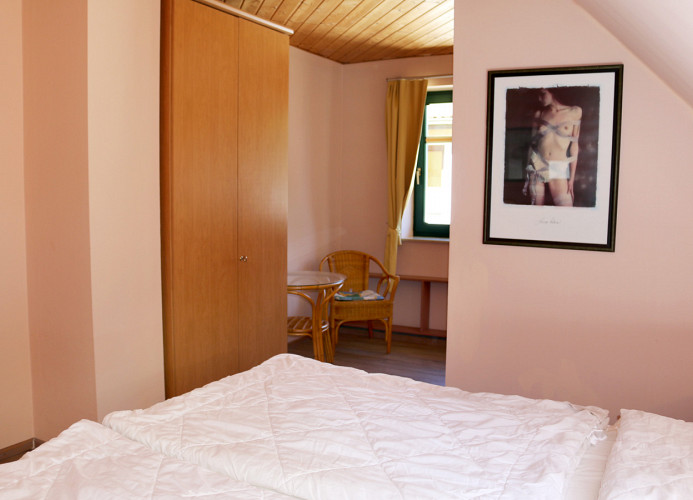 Schlafzimmer I - kleine Nische mit Sitzecke und Zugang zum eigenen Bad