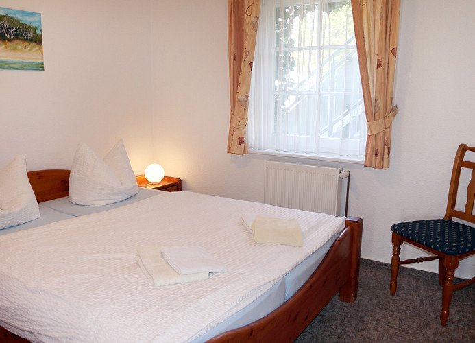 Schlafzimmer mit Doppelbett und Kleiderschrank