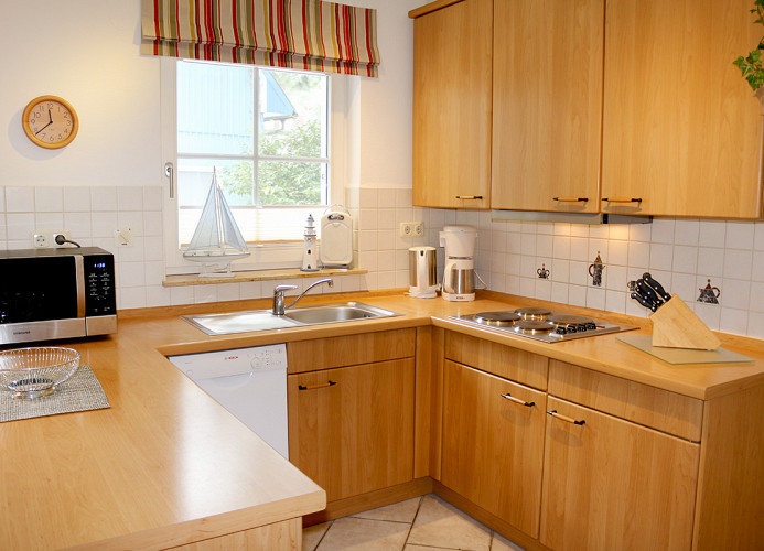 Küchenbereich mit 4-Platten Kochmulde, Kaffeemaschine, Backofen, Toaster, Wasserkocher, Kühlschrank mit Gefrierfach, Geschirrspüler