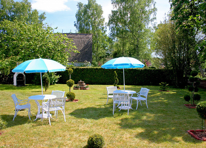 Gartensitzplätze mit Sonnenschirm im Grünen