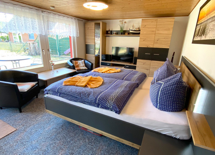 Wohn- Schlafraum mit Doppelbett, TV und Radio / Ausblick auf die Terrasse