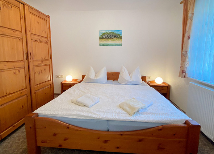 Schlafzimmer mit Doppelbett und Kleiderschrank