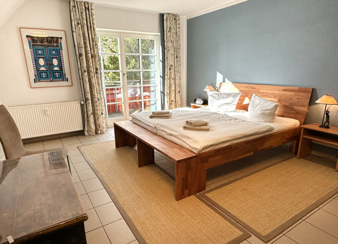 sehr geräumiges Schlafzimmer mit Doppelbett und Zugang zum Balkon