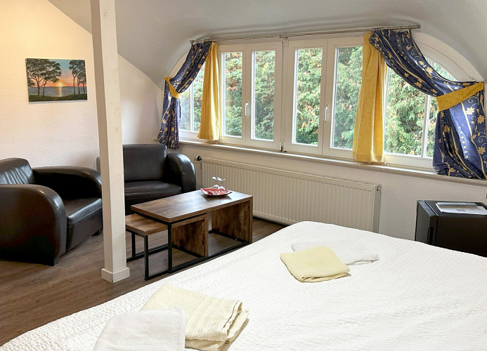 Zimmer mit Doppelbett und kleiner Sitzecke