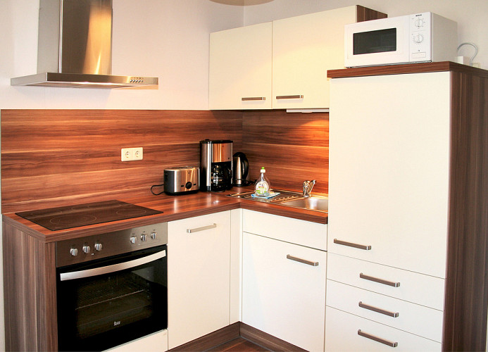 Küche mit Cerankochfeld, Backofen, Geschirrspüler, Mikrowelle, Kaffeemaschine, Geschirr usw.