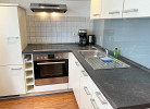 Küche mit Backofen, Cerankochfeld, Kaffeemaschine, Wasserkocher, Toaster, ausreichend Geschirr, Kühlschrank (mit Gefrierfach)